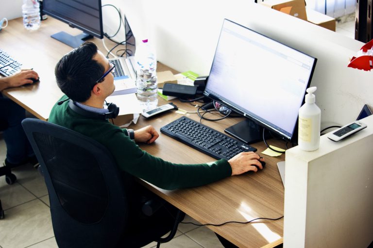 A Software Engineer works at the headquarters of Alpha Si with their company-provided computer, which is assigned to each employee