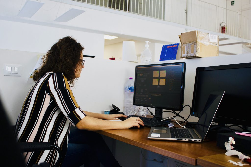 A Software Engineer works at the headquarters of Alpha Si with their company-provided computer, which is assigned to each employee