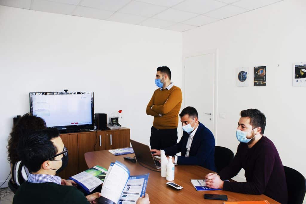A Software Engineer works at the headquarters of Alpha Si with their company-provided computer, which is assigned to each employee